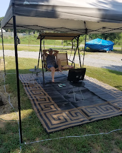 Guest relaxing under a shade canopy at their RV site